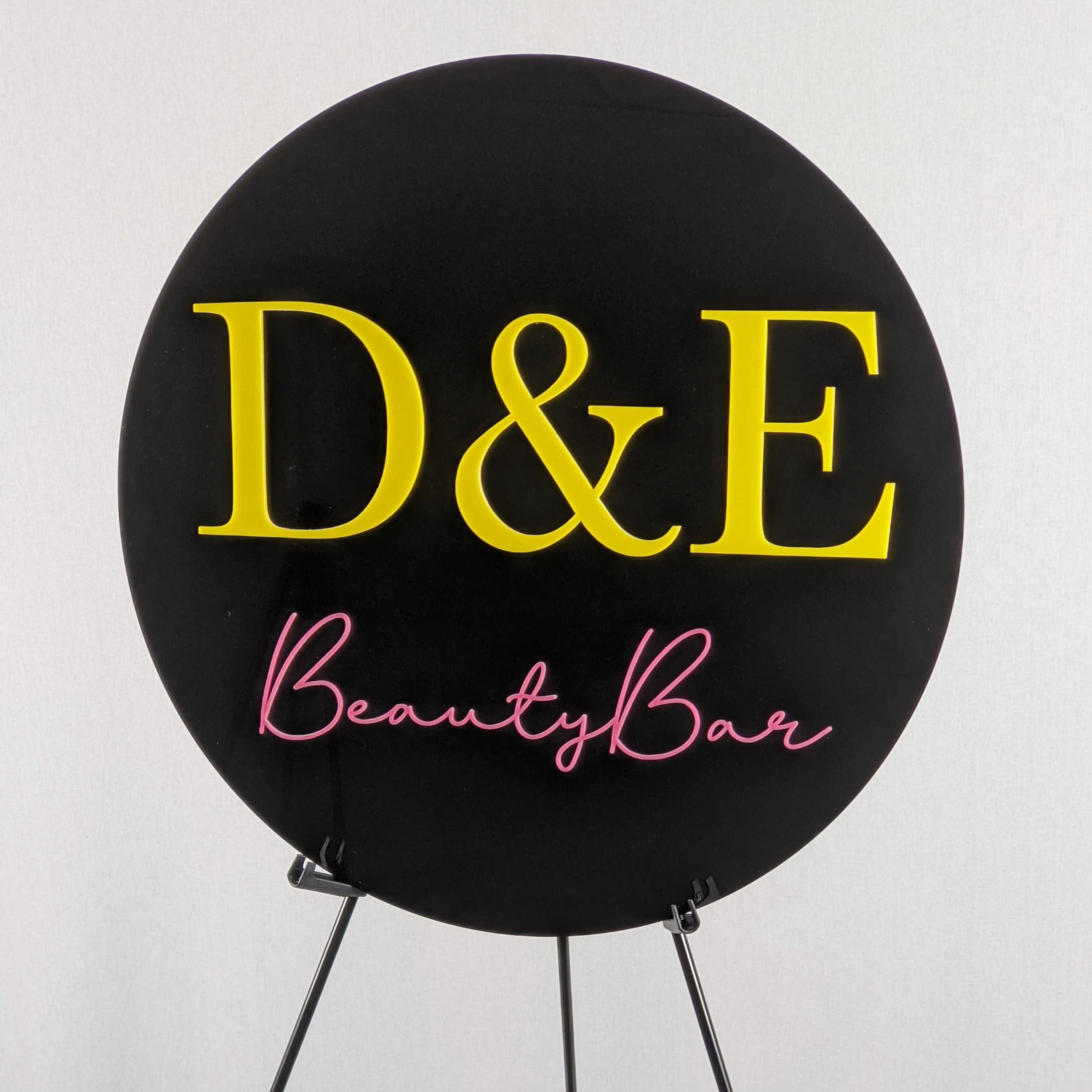 D&E Beauty Bar round sign