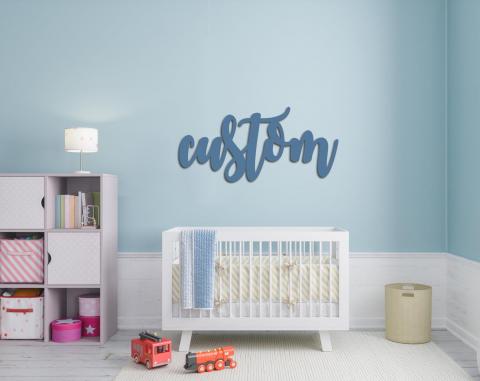 wood name sign on nursery wall