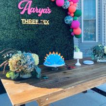 Pink and gold mirror sign on hedge wall